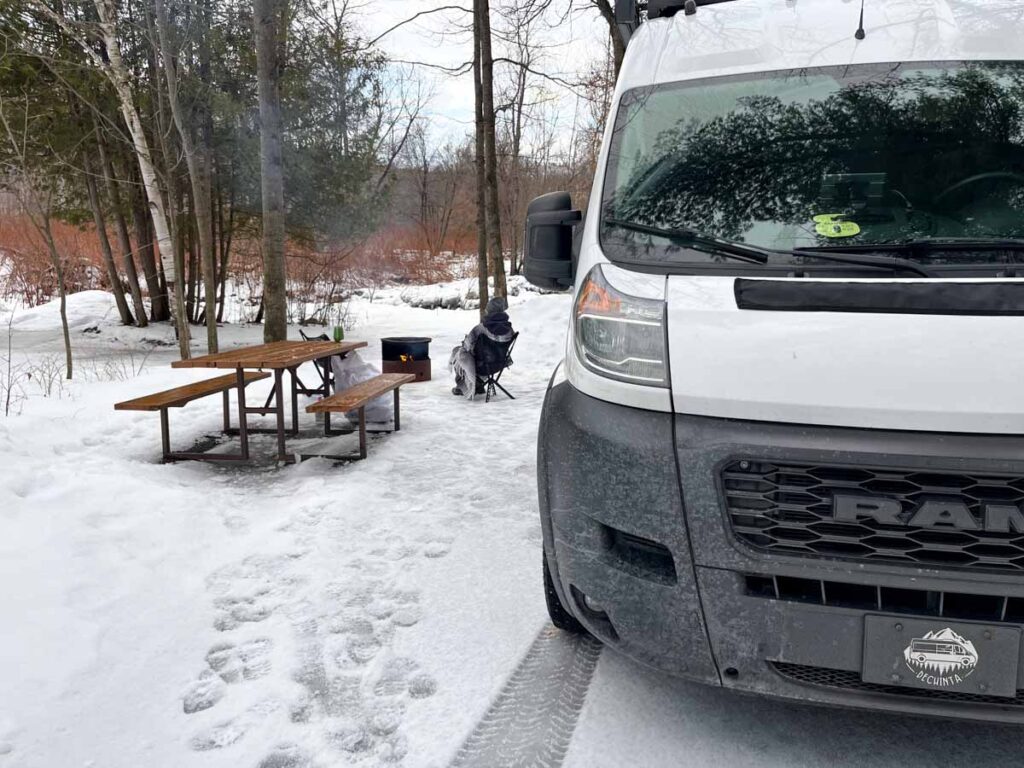 Van dans son emplacement de camping près de la rivière avec un feu de camp - Van in its campsite near the river with a campfire